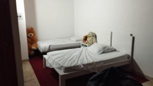 een kamer met 2 bedden en een teddybeer bij La Casa de Yeny in Borrero Ayerbe