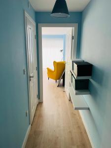 un pasillo con una silla amarilla en una habitación en Ades en Leeds