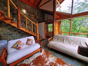 - un salon avec un canapé et un mur en pierre dans l'établissement Patagonia Villa Lodge, à Ushuaia