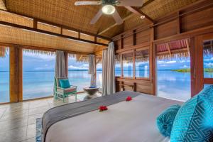 a bedroom with a bed and a view of the ocean at Azul Over-the-Water Resort in Bocas Town