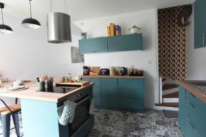 a kitchen with blue cabinets and a counter at Maison cosy dans le centre ville de Lens in Lens