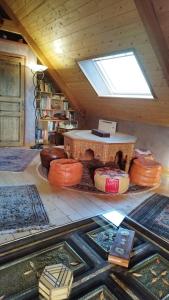 ein Dachzimmer mit einem Tisch und vielen Teppichen in der Unterkunft Gite Esprit du Monde in Kervignac