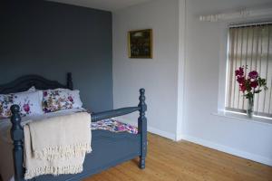 una camera con un letto blu e una finestra di North Coast country home(Portrush,Portstewart,Giant's Causeway) a Balnamore