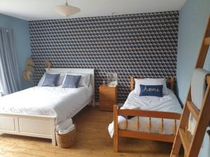 a bedroom with two beds and a blue and white wall at North Coast country home(Portrush,Portstewart,Giant's Causeway) in Balnamore