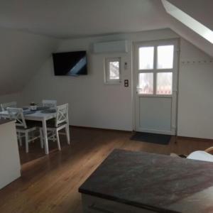a living room with a table and a window and a door at Anno Apartman ll. in Balatonföldvár +7 photos