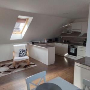 a kitchen with a table and a chair in a room at Anno Apartman ll. in Balatonföldvár