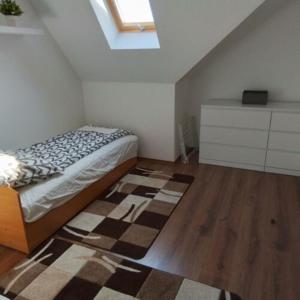 1 dormitorio con cama y alfombra en el suelo en Anno Apartman ll., en Balatonföldvár