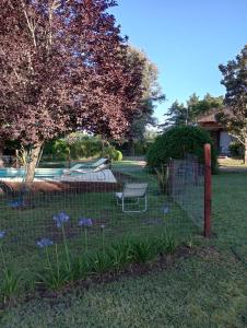 a fence with a bench in a yard with flowers at Finca El Amparo in Los Reartes