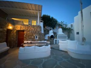 a courtyard with white chairs and a building at Flaskos Village Fanari in Mýkonos City