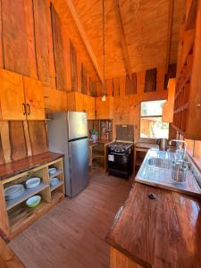 a large kitchen with wooden walls and a wooden floor at Kumewe Lodge in Panguipulli