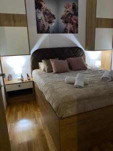 a bedroom with a large bed with a headboard at Apartman Akiluz & SPA Zlatibor in Zlatibor