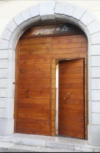 una porta del garage in legno con un cartello sopra di LadimoradiLu' a Piano