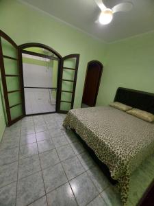 a bedroom with a bed and a large mirror at CASA DISPONÍVEL PARA TEMPORADA in Bertioga