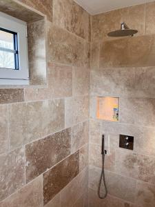 a bathroom with a shower with a stone wall at Reethaus Mellnitz in Mellnitz