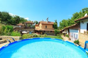 a large swimming pool in a yard with a house at Chamurkov Guest House in Veliko Tŭrnovo