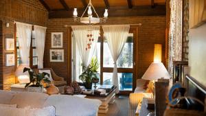 a living room with white furniture and a brick wall at Morada das Bromélias in Torres