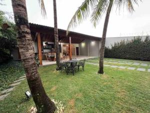une arrière-cour avec une table et deux palmiers dans l'établissement Residencial Bem-te-vi, à Matão