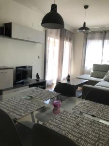 salon z kanapą i stołem z krzesłami w obiekcie Apartamento Migdia-Moraira w mieście Moraira