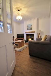 a living room with a couch and a fireplace at Kindly Light Cottage in Amble