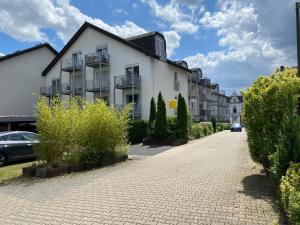 um edifício branco numa rua com arbustos em Appartement House Dortmund "Lounge Appartement" em Dortmund