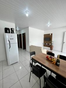 cocina con mesa y nevera blanca en Apartamento em Porto Belo, en Porto Belo