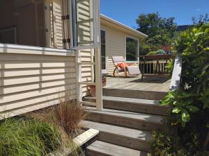 eine Holztreppe, die zu einer Veranda eines Hauses führt in der Unterkunft Cottage House in Wellington
