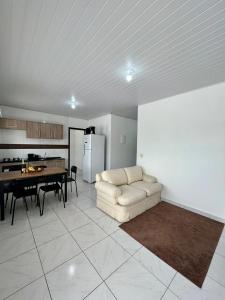 sala de estar con sofá, mesa y cocina en Apartamento em Porto Belo, en Porto Belo