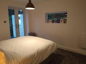 a bedroom with a bed and a picture on the wall at Mountain Lodge with magical views in Pentyrch