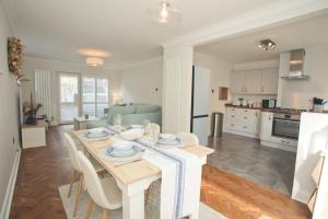 a kitchen and living room with a table and chairs at Chine Wood Retreat - Walk to the beach and the lovely Westbourne - Free parking in Bournemouth