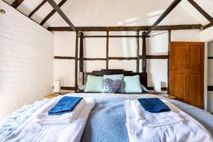 ein Schlafzimmer mit einem großen Bett mit Handtüchern darauf in der Unterkunft Beautiful 17th Century Cottage in Buckinghamshire + 33 Fotos