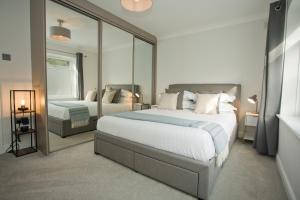 um quarto com 2 camas e um espelho grande em Chine Wood Retreat - Walk to the beach and the lovely Westbourne - Free parking em Bournemouth