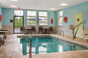 a pool with chairs and tables in a building at Comfort Inn University in Amherst