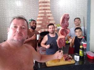 un hombre sosteniendo un gran pedazo de carne en una tabla de cortar en espaço 16, en Maricá 2 fotos más