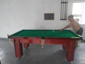 un hombre está jugando al billar en una mesa de billar en espaço 16, en Maricá