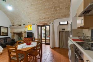 a kitchen and living room with a table and chairs at Corte Regina in Sogliano Cavour
