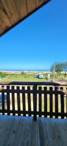 un banco en una terraza con vistas al océano en Chalé Mar a Vista Conforto e Pé na areia, en Arroio do Silva