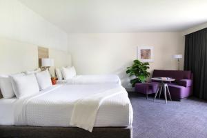 um quarto de hotel com duas camas e uma cadeira roxa em Crowne Plaza Atlanta Perimeter at Ravinia, an IHG Hotel em Atlanta