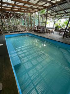 uma piscina com água azul numa casa em Hotel Ecológico Cabañas del Lago em El Estor