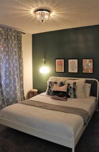 a bedroom with a large bed with a green wall at El Chuco Home W Pool, Pool Table,15 Min Downtown in El Paso