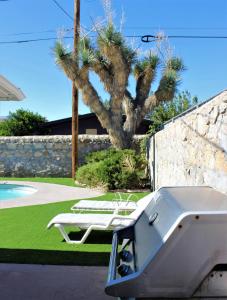 a pool with two lounge chairs next to a wall at El Chuco Home W Pool, Pool Table,15 Min Downtown in El Paso