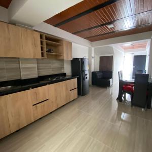 a kitchen with a black refrigerator and a table at Apartamento Confort Quindío in Calarcá