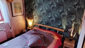 - une chambre dotée d'un lit avec du papier peint bleu et vert dans l'établissement Gite Esprit du Monde, à Kervignac