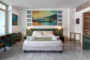 1 dormitorio con 1 cama y una pintura en la pared en Acquario Genova Suite, en Génova