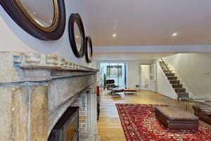 a living room with a stone fireplace and a couch at House by the sea in Kent