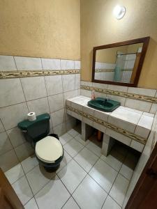 a bathroom with a toilet and a sink and a mirror at Hotel Ecológico Cabañas del Lago in El Estor +17 photos