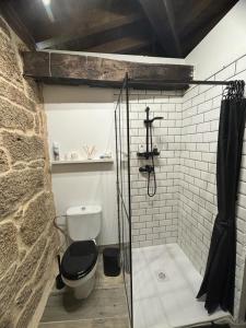 a bathroom with a toilet and a glass shower stall at ATURUXO 