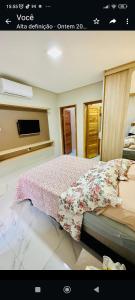 a bedroom with a bed with a floral bedspread at Casa Parque Minas in Córguinho