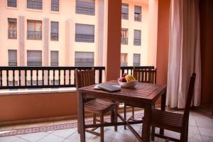 a table and chairs with a bowl of fruit on a balcony at Luxe apartment / Prime location / 2 bedr- 2.5 bathrooms in Marrakech