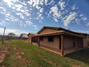 a small house with a roof on a field at Pousada do Chicó in São Roque de Minas