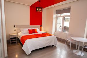 1 dormitorio con 1 cama con pared roja en Casa Esmeralda, en Valparaíso